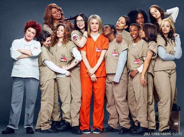 a group of women in orange uniforms posing for a photo with their arms around each other