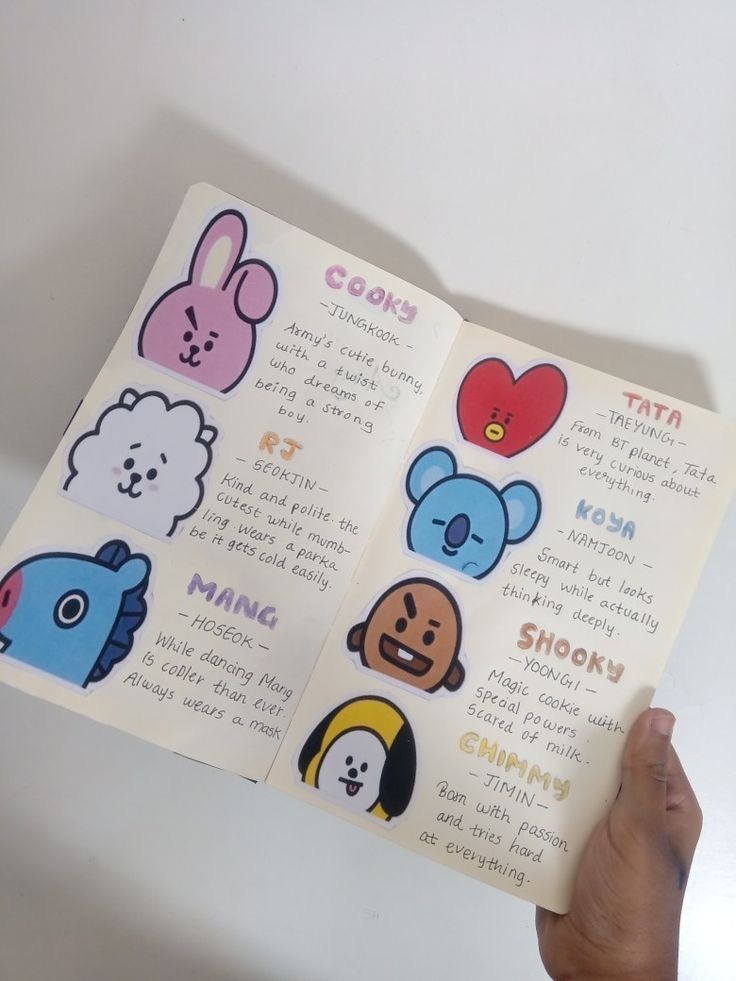 someone holding up a book with stickers on it