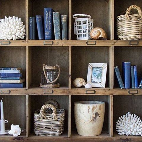 a book shelf filled with lots of books and other items on top of wooden shelves