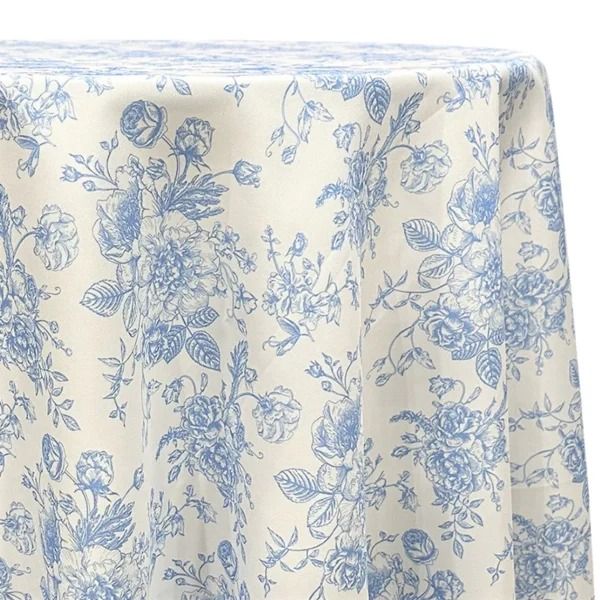 a blue and white table cloth with floral designs on the top, in front of a white background