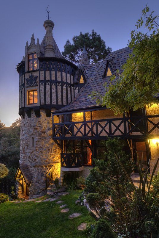 an old stone building with a clock on it's face and windows at night