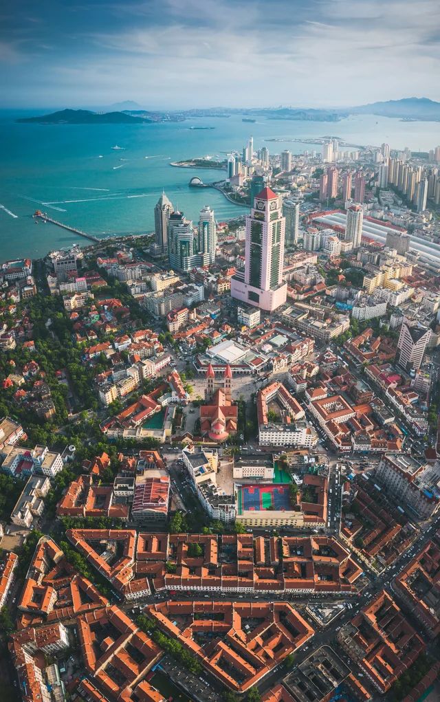 an aerial view of a large city next to the ocean with tall buildings on both sides