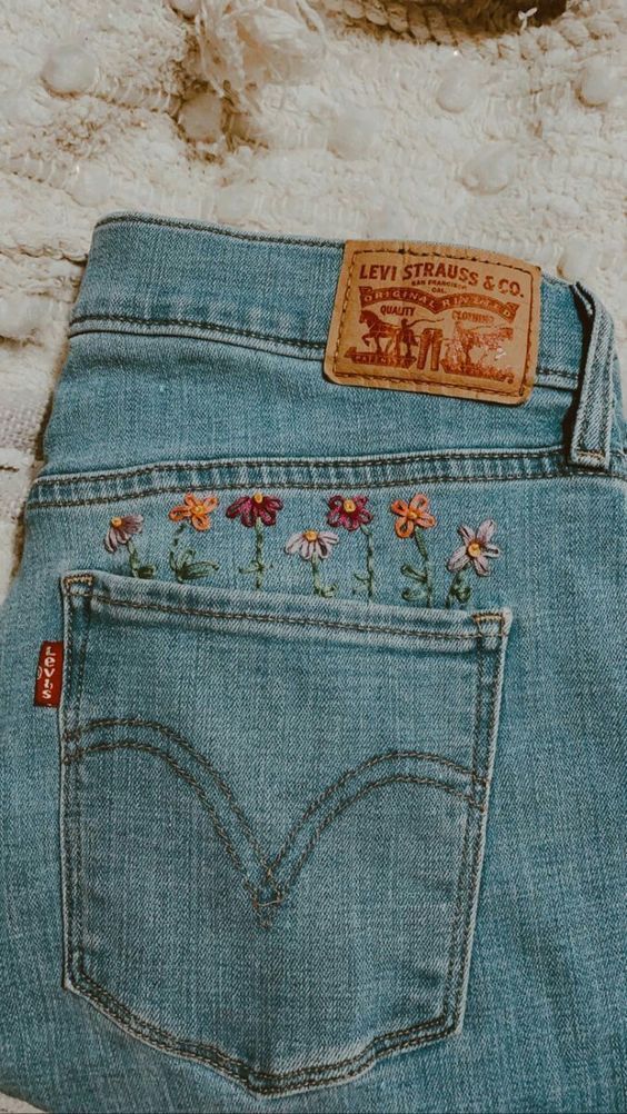 a pair of jeans with embroidered flowers on them