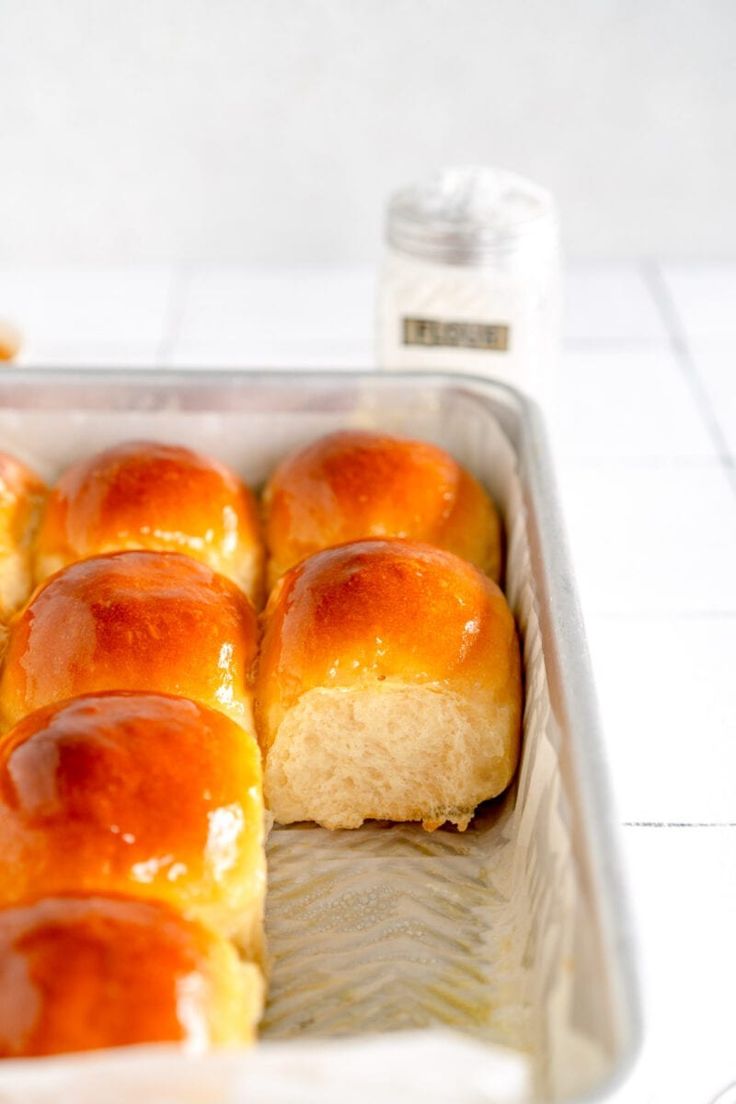 a pan filled with rolls covered in cheese and sitting on top of a white counter