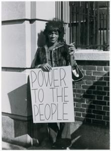 a man holding a sign that says power to the people