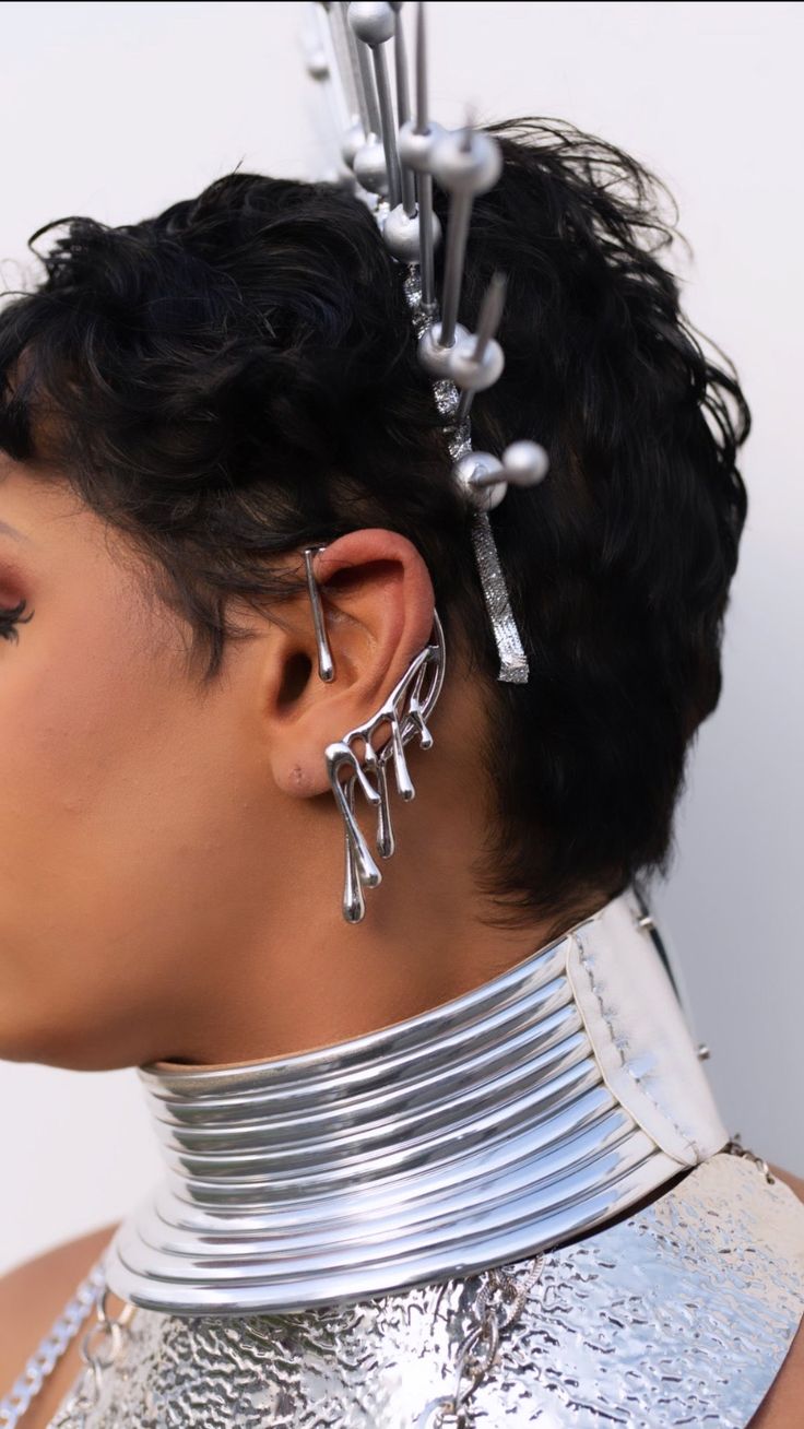 a close up of a person wearing metal jewelry