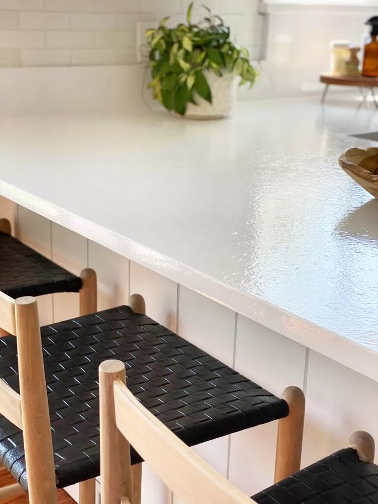 three stools sitting at the edge of a kitchen counter