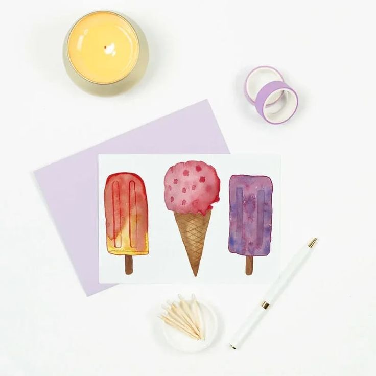 three ice creams on top of each other next to a candle and some scissors