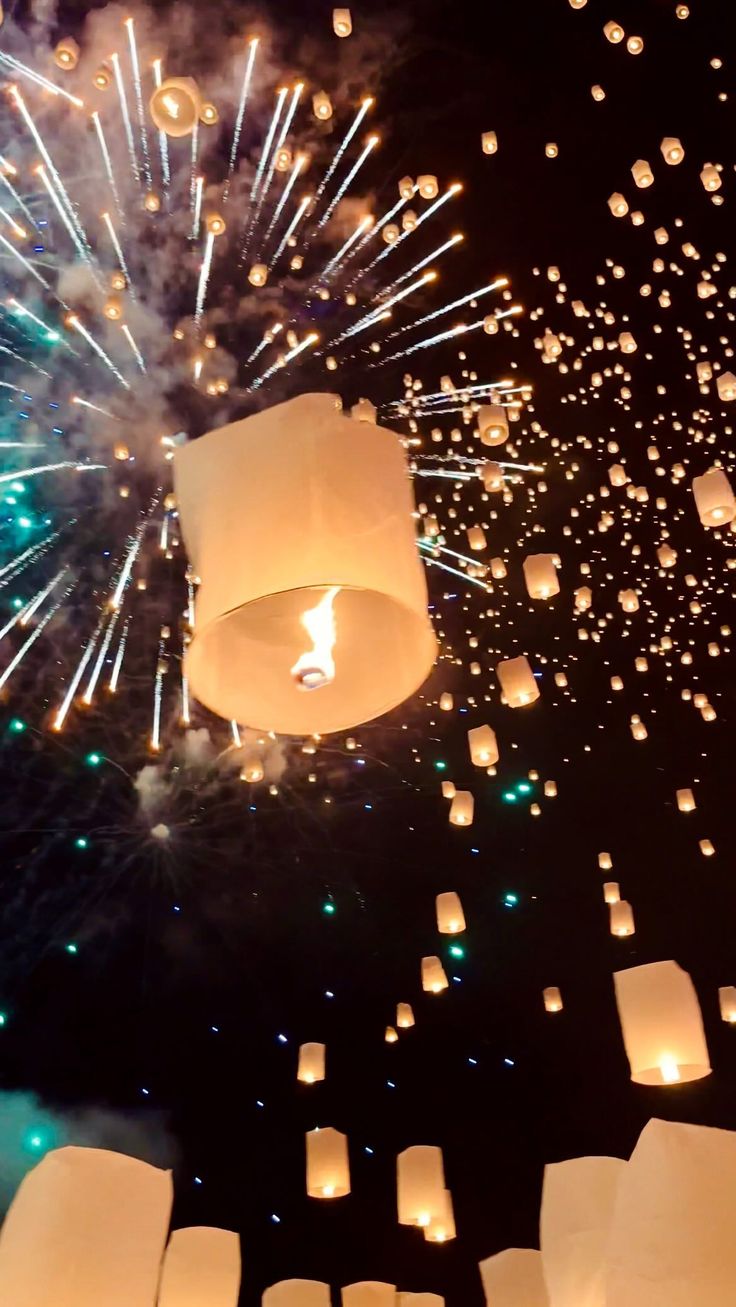 the sky is filled with lots of white paper lanterns floating in the air and lit up