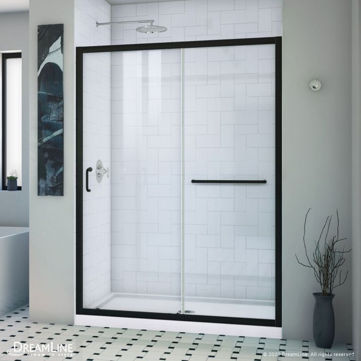 a black and white tiled bathroom with a walk in shower next to a tubtub