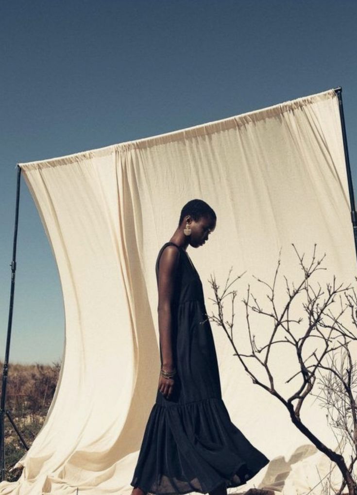 a woman standing in front of a white curtain