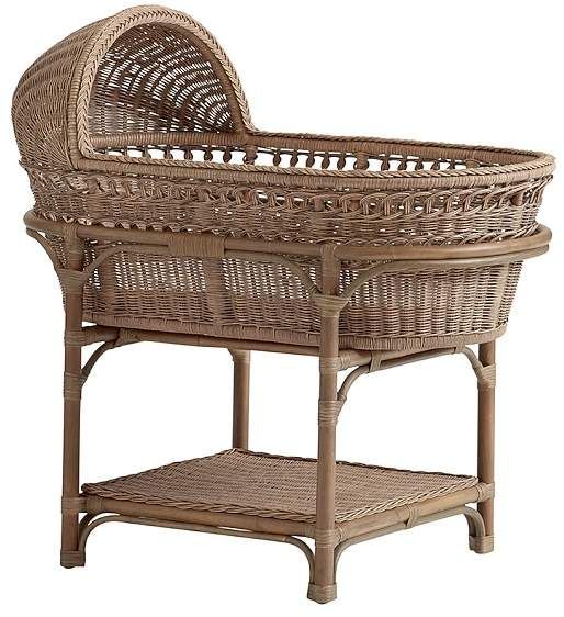 a wicker baby bassinet is shown on a white background with an empty shelf underneath it