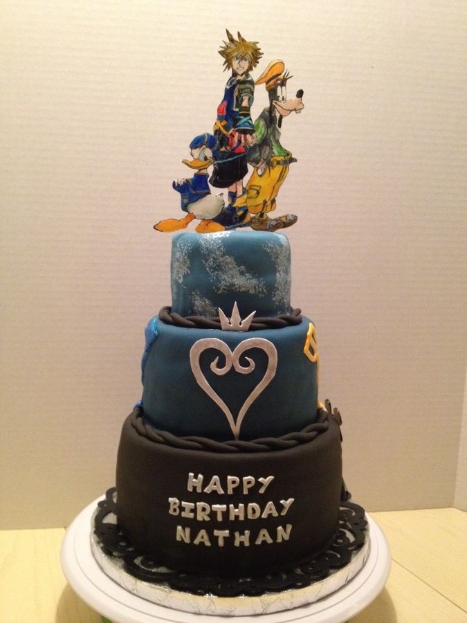 a three tiered birthday cake decorated with cartoon characters