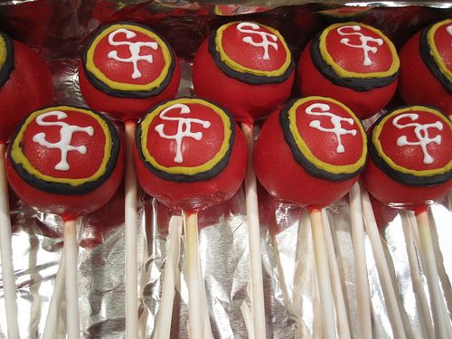 red cake pops with white frosting and chinese symbols on them are arranged in a row