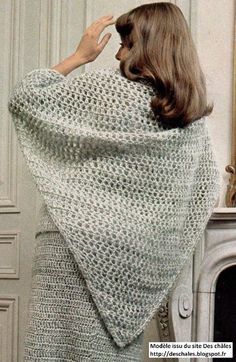 a woman is wrapped in a crocheted shawl with her hair back to the camera