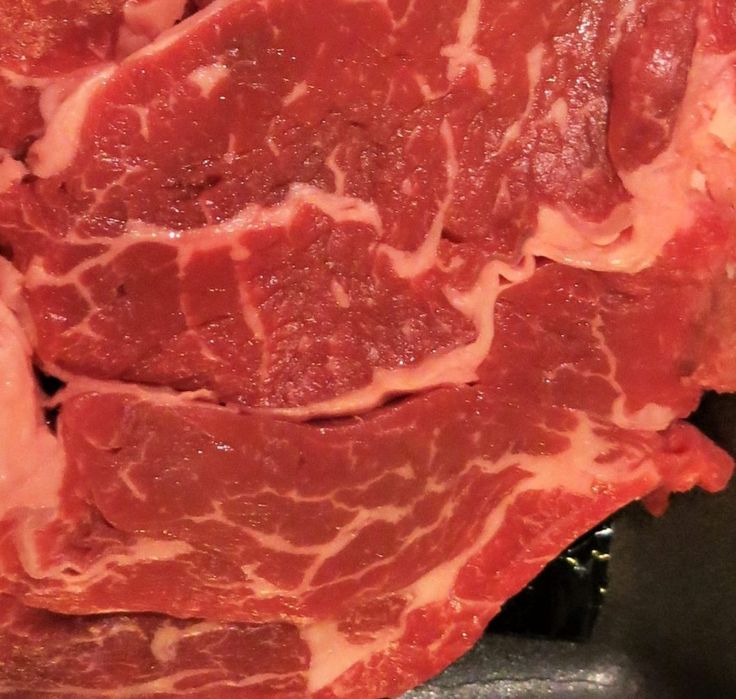 raw meat sitting on top of a metal pan