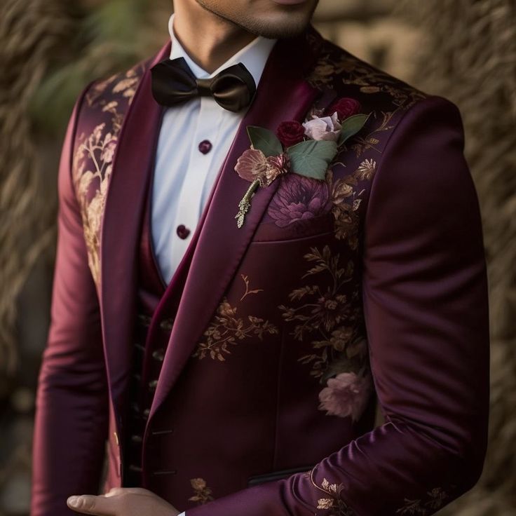 a man in a red suit and bow tie wearing a flowered boutonniere