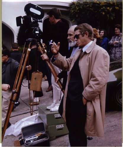 a man standing in front of a camera on top of a tripod next to other people