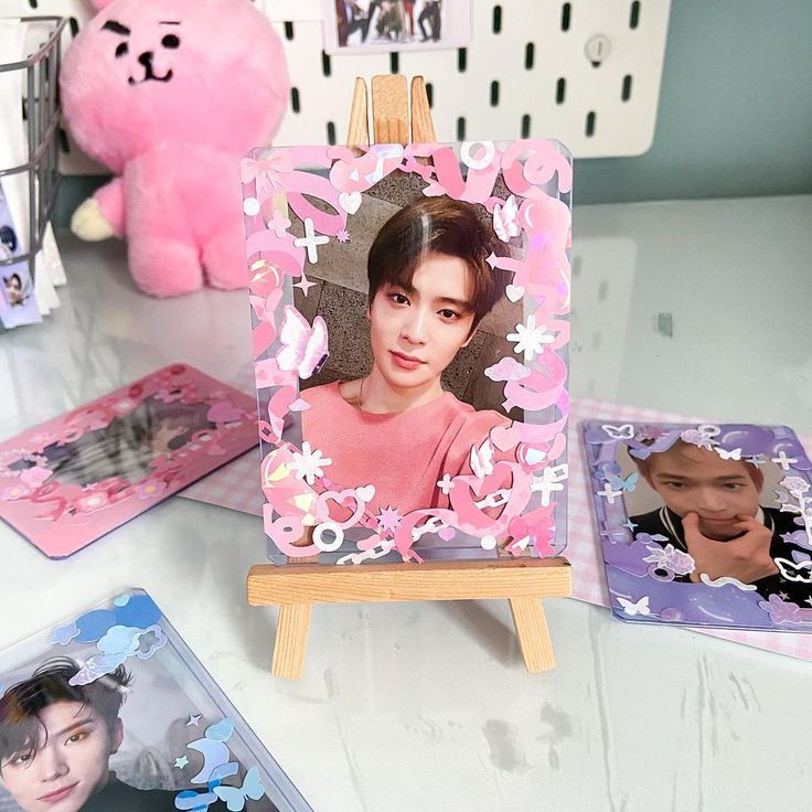 a table topped with pictures of people and a pink teddy bear