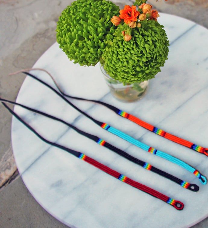 three different colored canes sitting on top of a marble table next to a potted plant