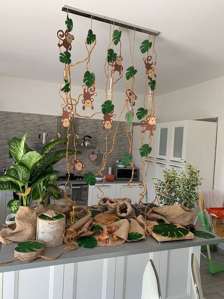 a kitchen counter topped with lots of green plants and decorations hanging from it's ceiling