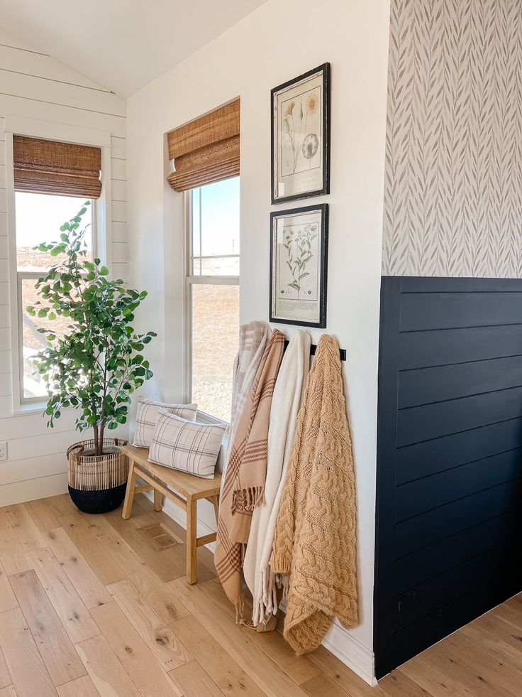 towels are hanging on the wall next to a bench with a potted plant in it