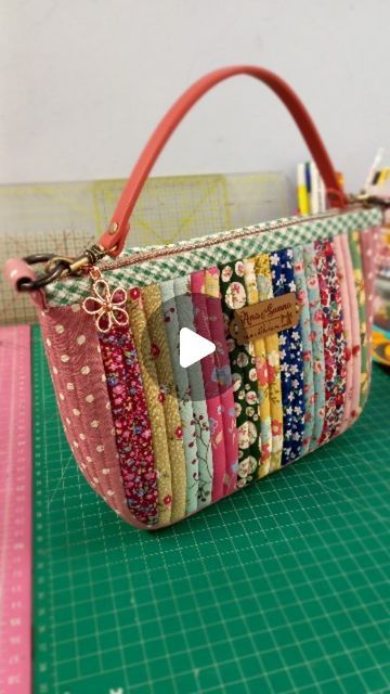 a handbag is sitting on top of a green cutting board with scissors and thread