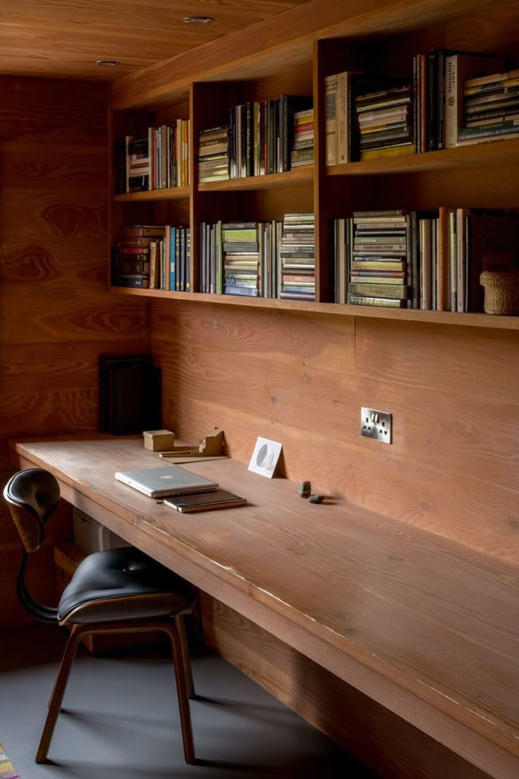 a wooden desk sitting in front of a book shelf filled with books