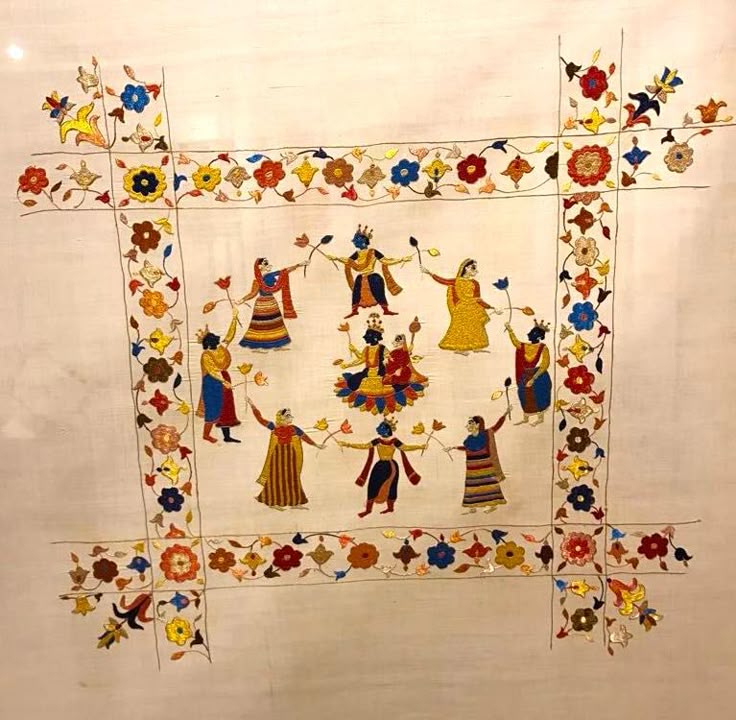 an embroidered wall hanging with people dancing and flowers on it's border, in front of a white background