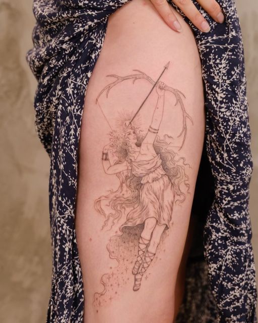 a woman's thigh with a tattoo on it that has an image of a person holding