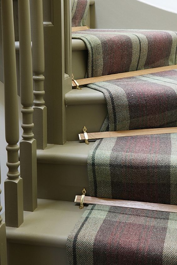 the carpeted stairs are lined with wooden handrails