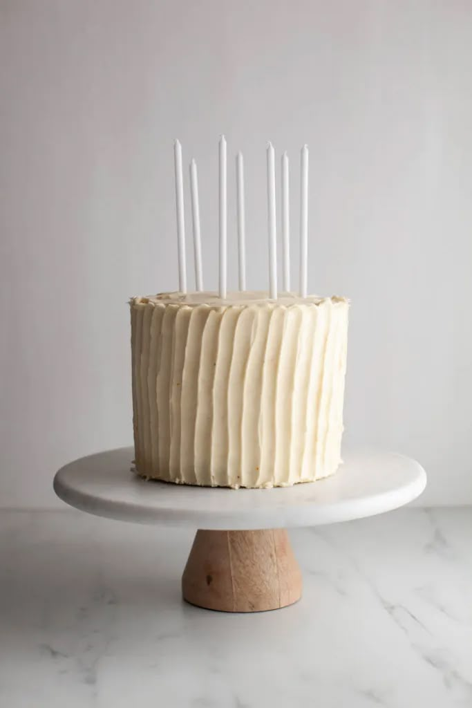 a cake with white frosting and candles on top