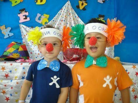 two young boys wearing clown noses and hair in front of a birthday party table with decorations