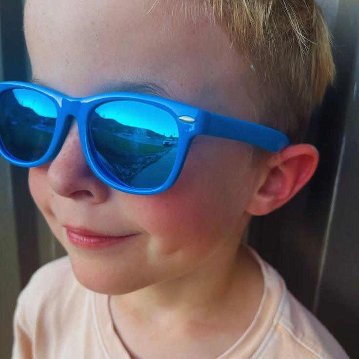 Elevate your child's style with our Blue Kids Ray-Ban Sunglasses. These iconic shades feature a sleek blue frame, reminiscent of the classic Ray-Ban design. Designed to provide both fashion and functionality, these sunglasses offer UV protection while adding a touch of cool sophistication to any outfit. Let your little one shine with confidence and timeless style, as they rock these must-have blue Ray-Ban sunglasses. Blue Fun Sunglasses With Tinted Lenses, Blue Tinted Fun Sunglasses, Blue Plastic Sunglasses With Mirrored Lenses, Fun Blue Tinted Sunglasses, Blue Mirrored Plastic Sunglasses, Blue Plastic Sunglasses With Uva Protection, Blue Wayfarer Sunglasses With Mirrored Lenses, Fun Blue Polarized Sunglasses, Blue Polarized Plastic Sunglasses