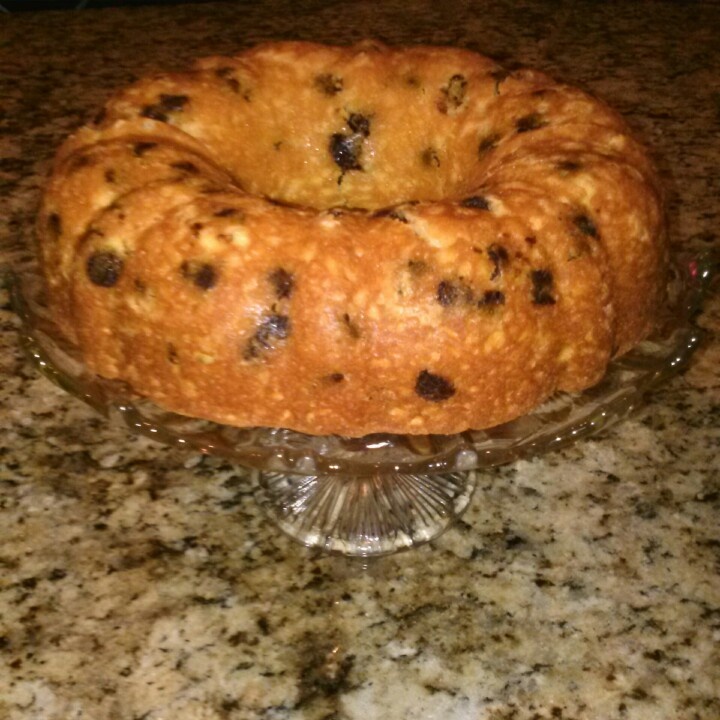 a loaf of bread sitting on top of a glass cake plate in front of a granite counter