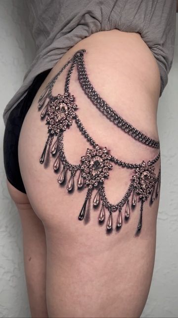 a woman's thigh with an intricate tattoo design on the side and bottom part