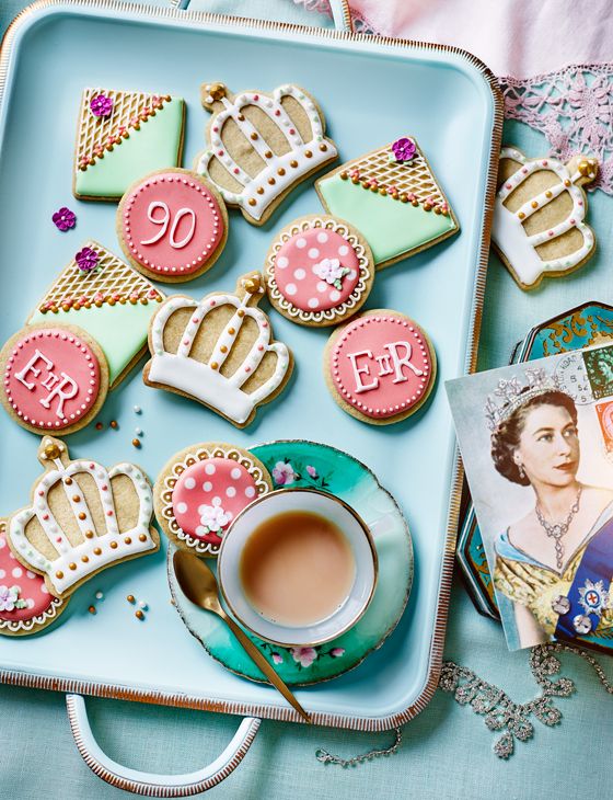 some cookies are on a blue plate and next to a cup of tea with the letter e