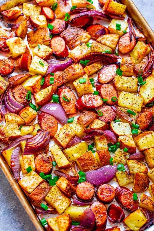 a casserole dish filled with potatoes, onions and sausage