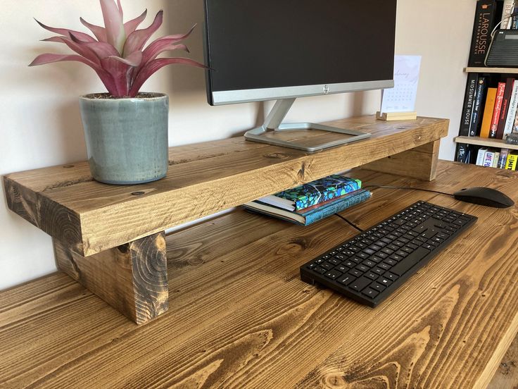 a computer monitor sitting on top of a wooden desk next to a keyboard and mouse