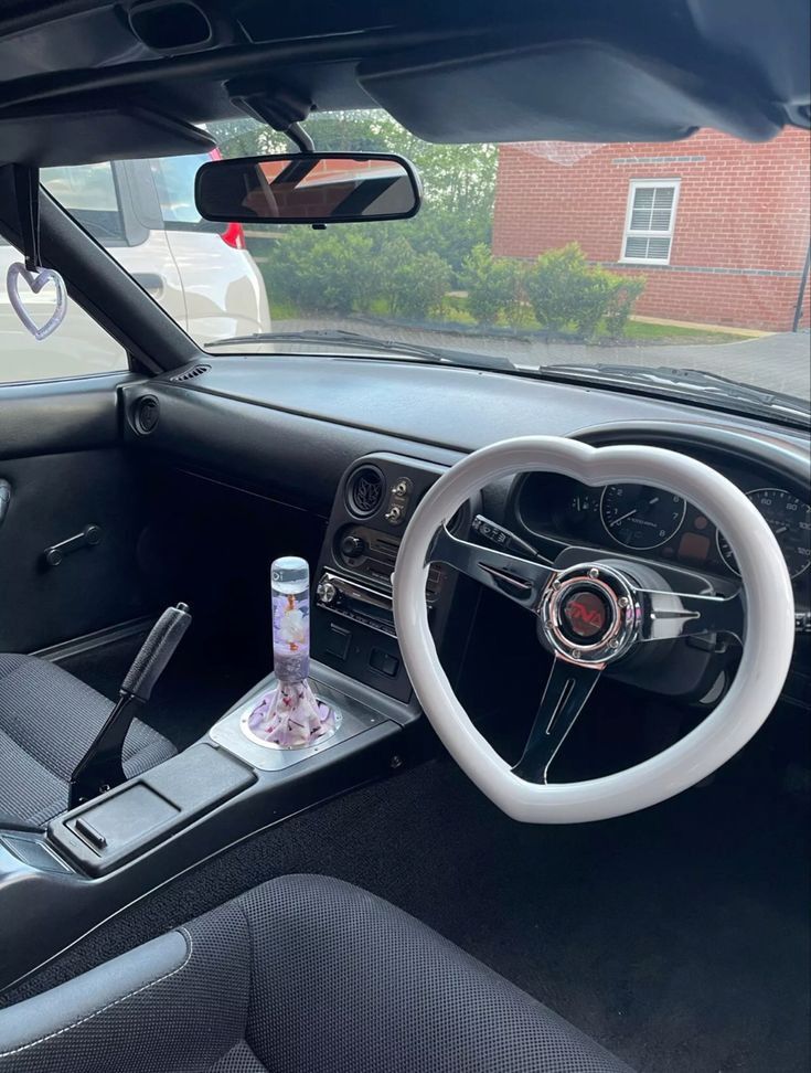 the interior of a car with a steering wheel, dashboard and other items in it