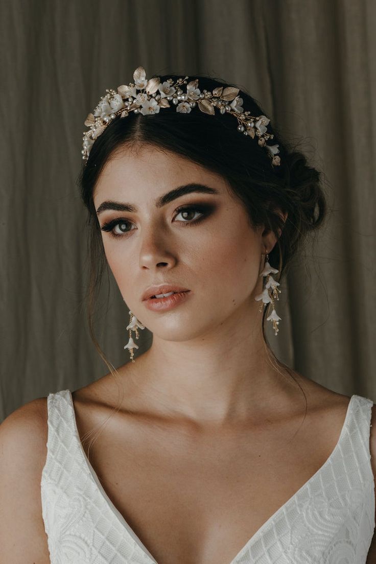 a woman wearing a bridal headpiece with flowers