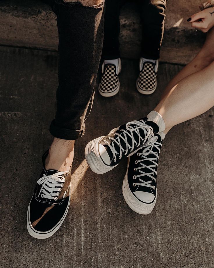 two people sitting on the ground with their feet propped against each other's legs