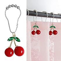 two cherries hanging from the side of a curtain