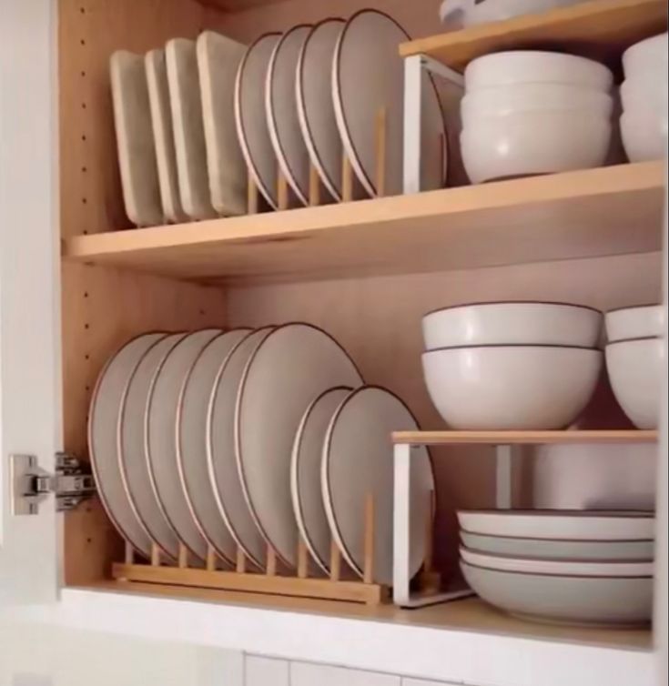 dishes and bowls are stacked on wooden shelves