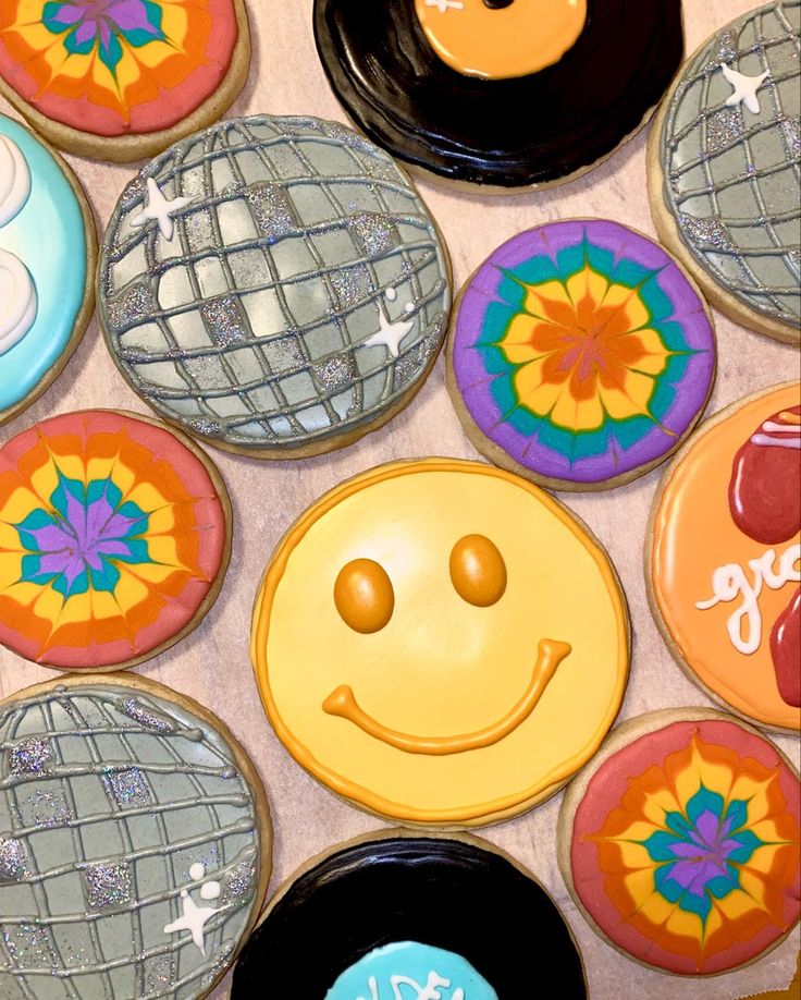 there are many decorated cookies with smiley faces on them, and one has a disco ball in the middle