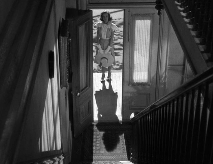 a woman is walking down the stairs in an old house with luggage on her feet