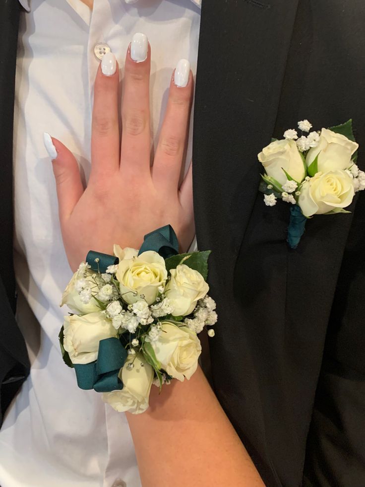 the bride and groom are wearing matching boutonnieres with flowers on their fingers