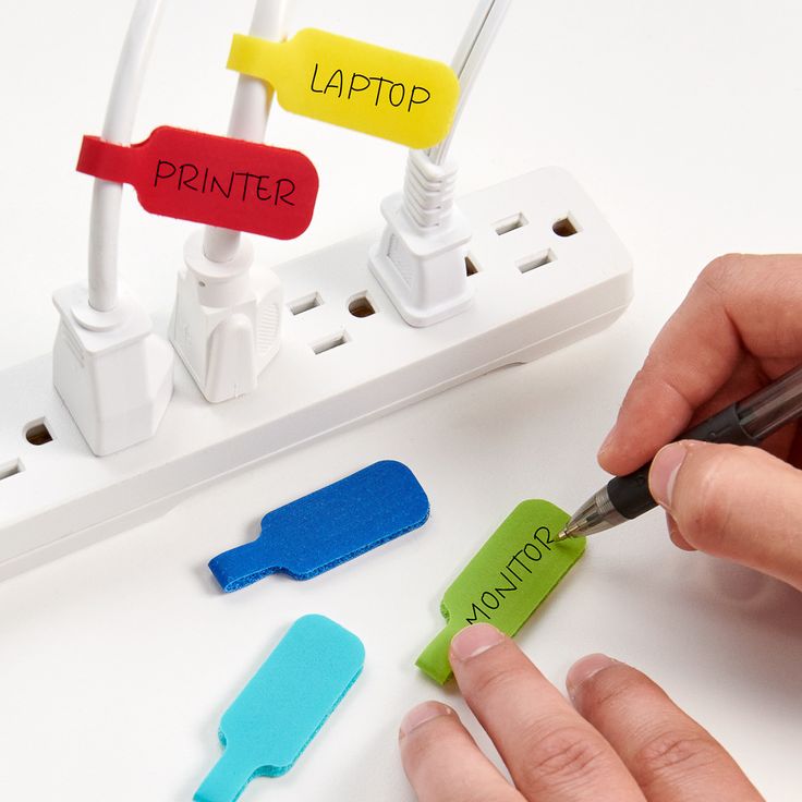 a person is writing on an electrical outlet with colored clips and wires attached to it