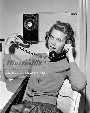 a woman sitting in a chair while talking on the phone