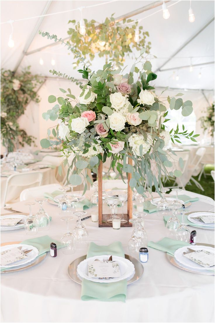 the table is set with white and green flowers